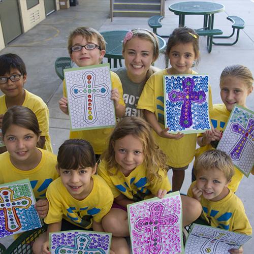 Female student with young children showing their artwork